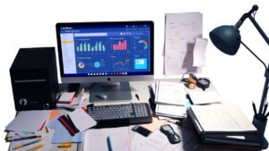 Een rommelig kantoorbureau met Dolibarr ERP CRM-software op computerscherm.